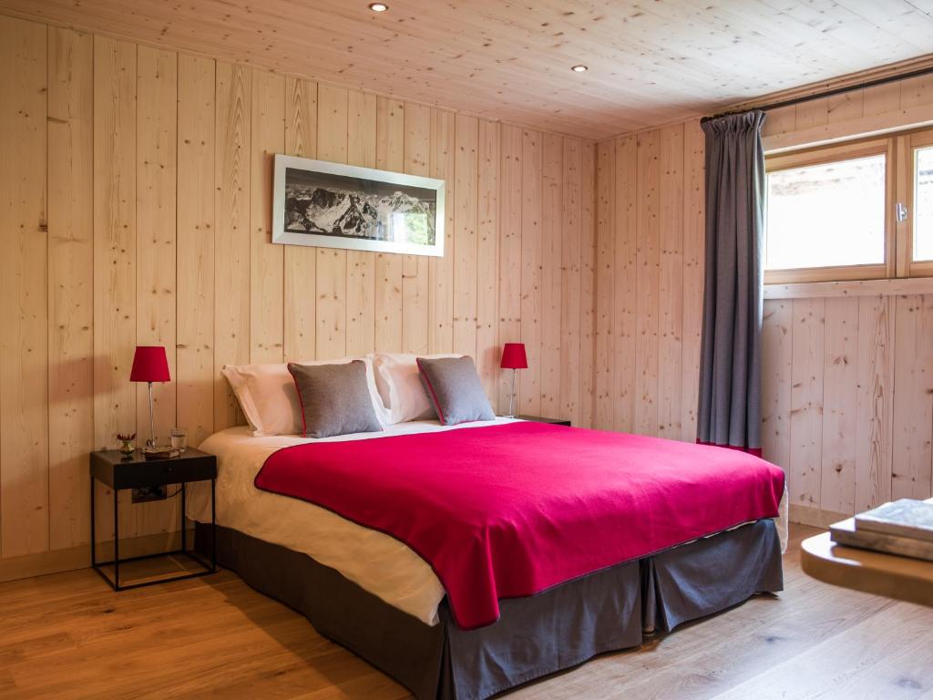 a bedroom with a large bed with a pink blanket at Les Chalets des Liarets in Chamonix
