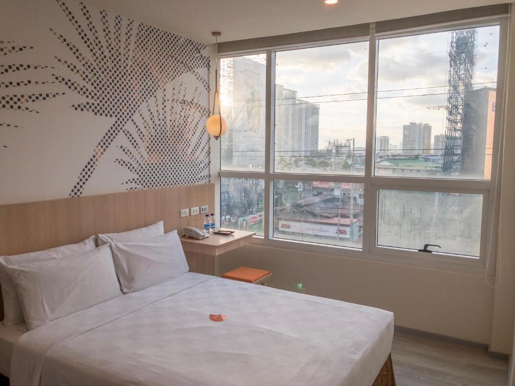 1 dormitorio con cama y ventana grande en Go Hotels Plus Mandaluyong en Manila