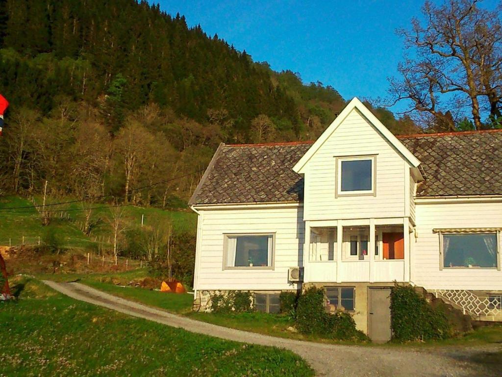 a white house sitting on top of a green field at 6 person holiday home in LONEVÅG-By Traum in Lonevåg