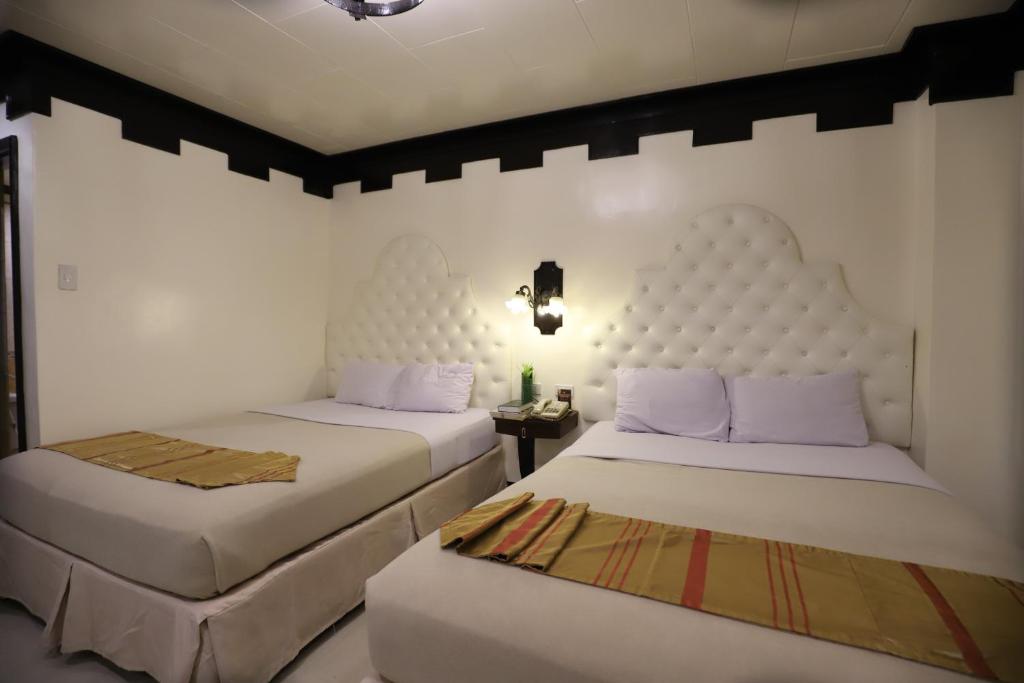 Postel nebo postele na pokoji v ubytování Camelot Hotel Quezon City powered by Cocotel