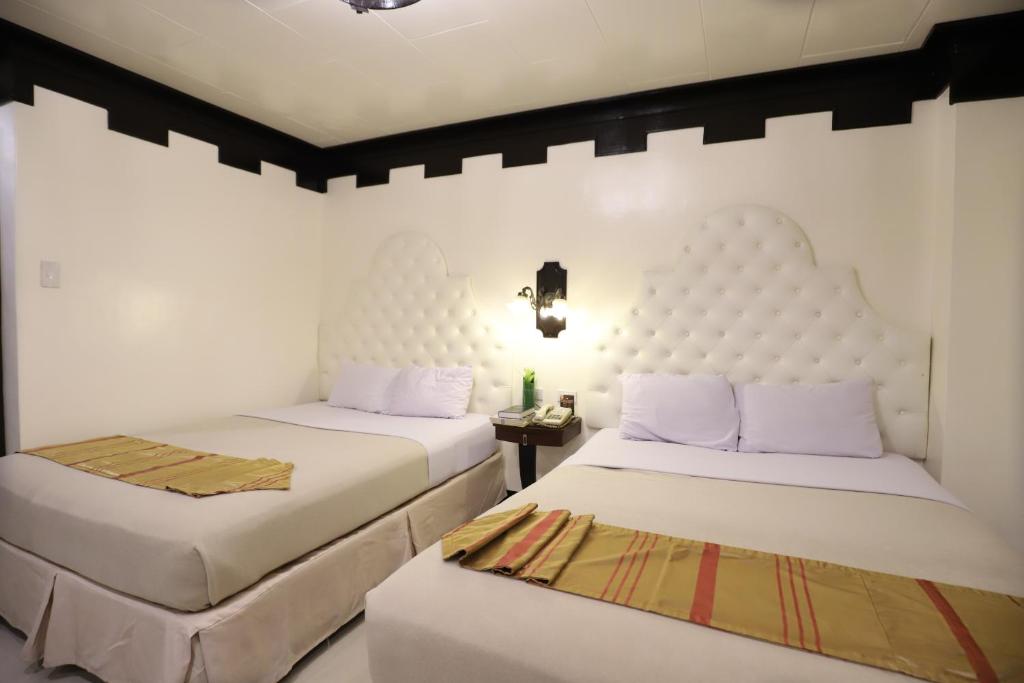 Postel nebo postele na pokoji v ubytování Camelot Hotel Quezon City powered by Cocotel