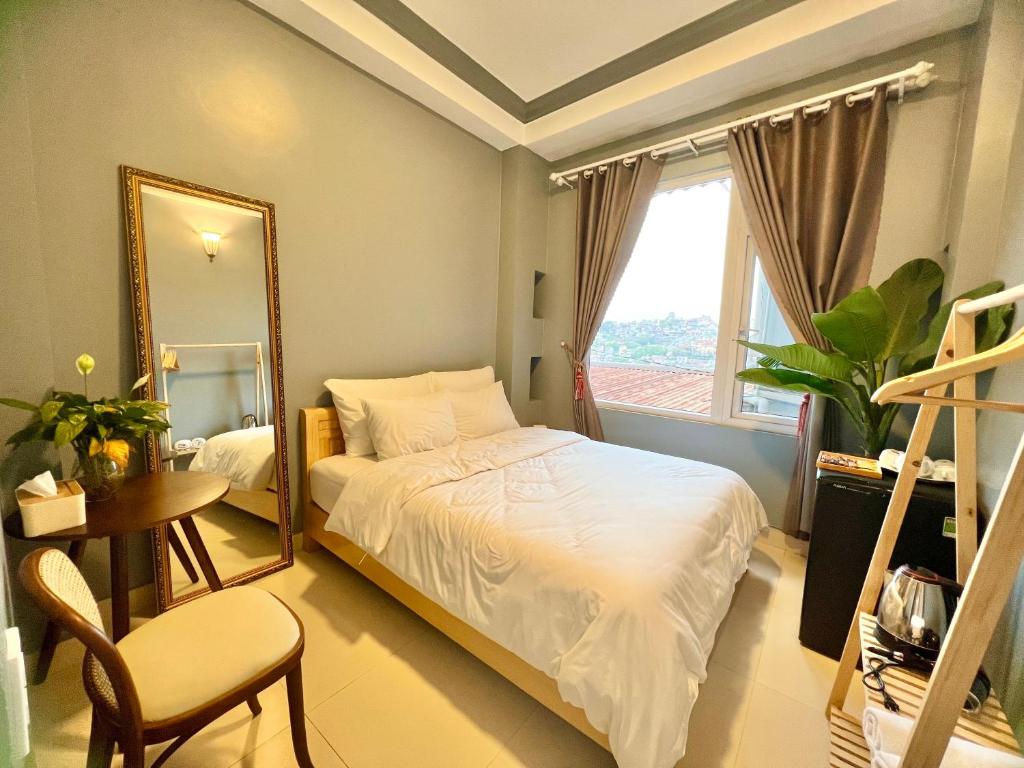 um quarto com uma cama com um espelho e uma cadeira em Nhà An Đà Lạt em Da Lat