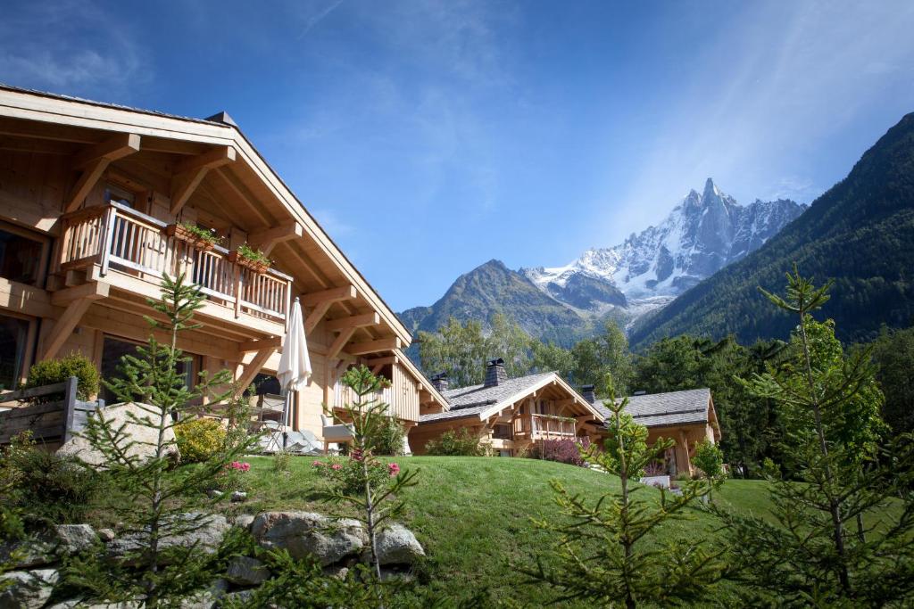 un grand bâtiment avec des montagnes en arrière-plan dans l'établissement Les Chalets des Liarets, à Chamonix-Mont-Blanc