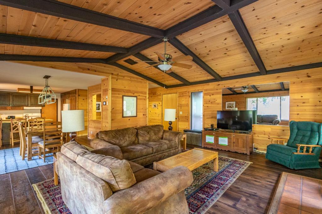 a living room with leather couches and a dining room at Yosemite Big Rock Cabin in Fish Camp