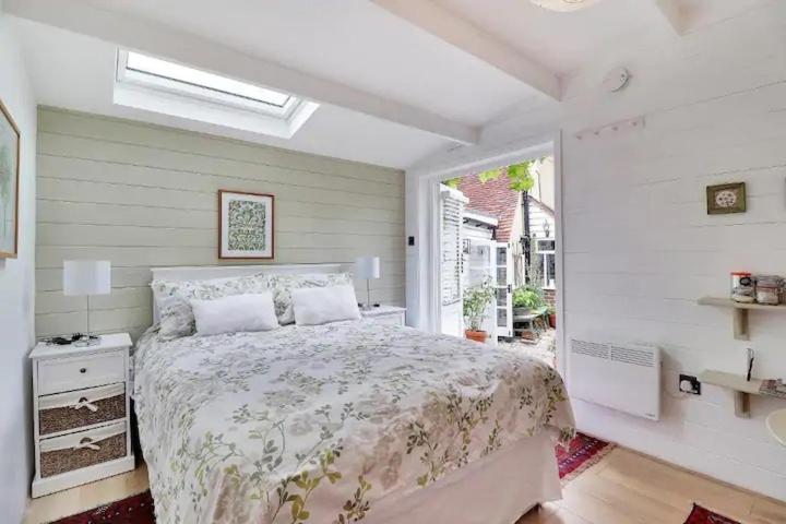 Un dormitorio con una cama grande y una ventana en Garden Studio, en Cranbrook