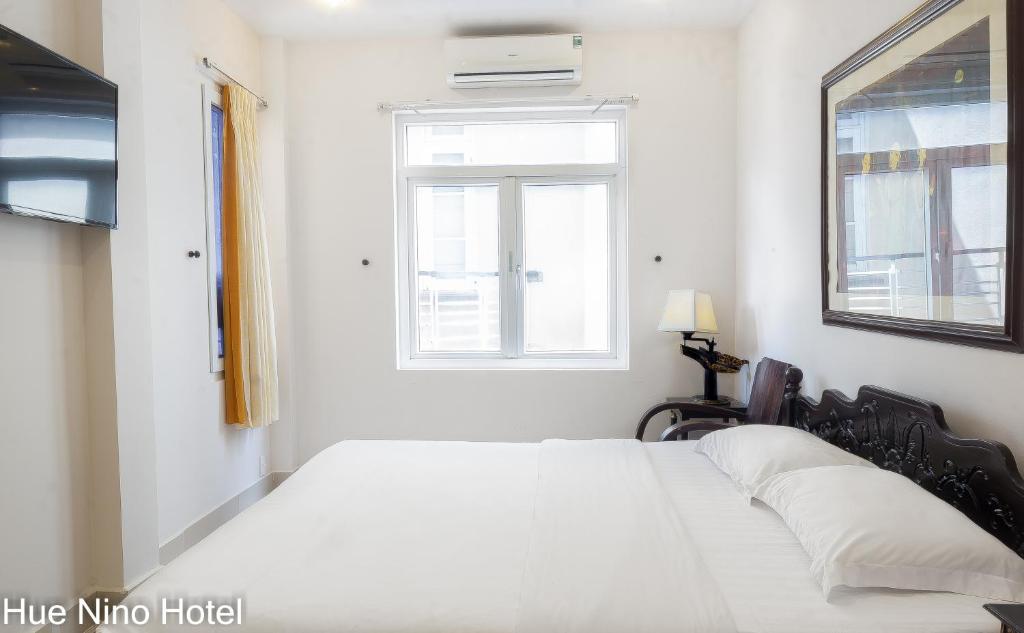 Postel nebo postele na pokoji v ubytování Hue Nino Hotel