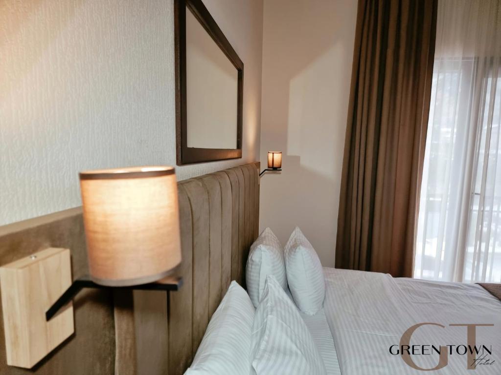 a hotel room with a bed with a lamp on it at Hotel Green Town in Kutaisi