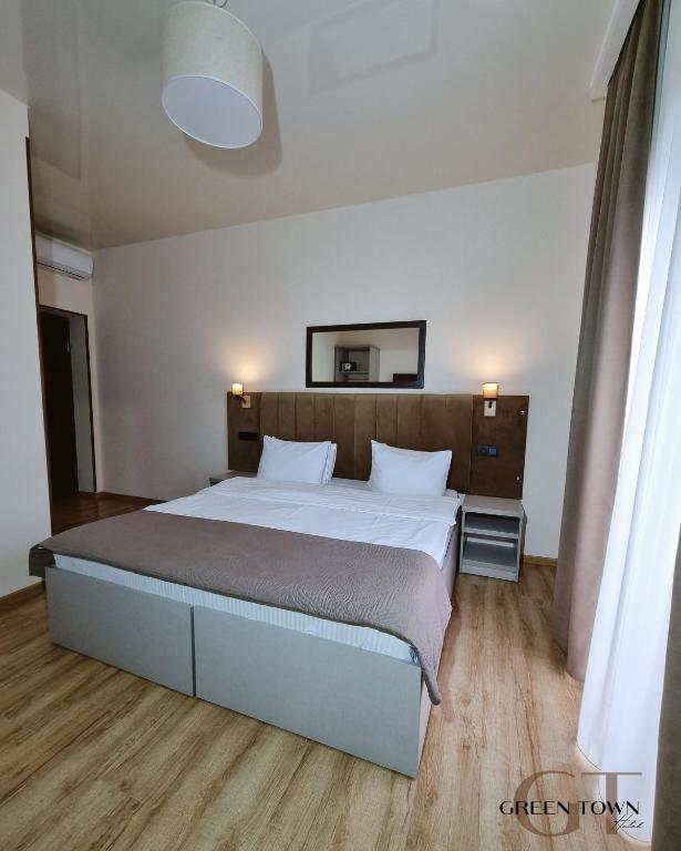 a bedroom with a bed and a mirror on the wall at Hotel Green Town in Kutaisi