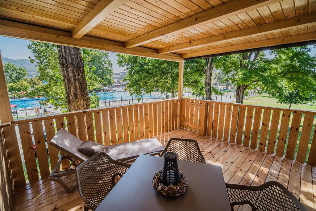 una terraza de madera con mesa y sillas. en Premium Mobile Tree House with Thermal Riviera Tickets en Čatež ob Savi