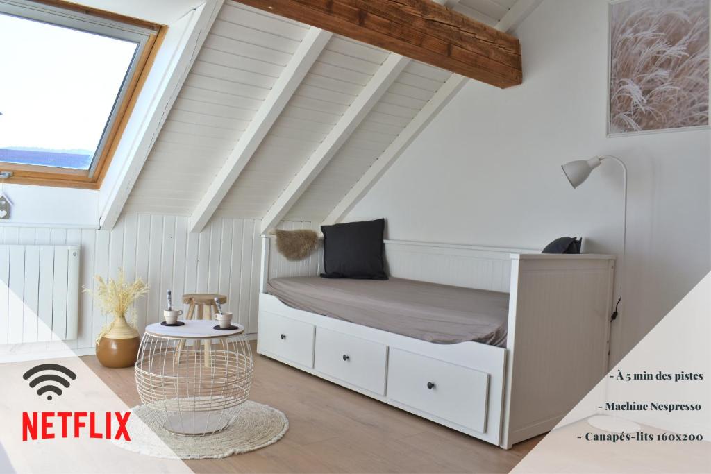 ein Schlafzimmer mit einem Bett im Dachgeschoss in der Unterkunft bel appartement dans la montagne, L'orée du Bois in Mouthe