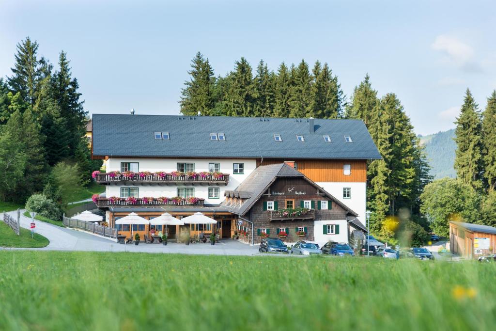 duży hotel z samochodami zaparkowanymi przed nim w obiekcie Gasthof Unterberger w mieście Sankt Kathrein am Offenegg