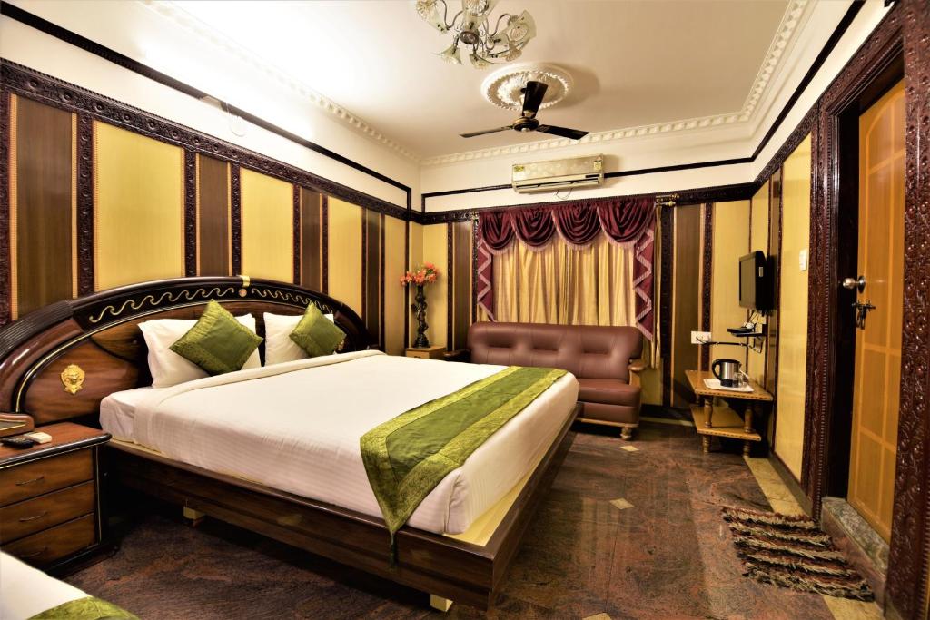 una stanza d'albergo con un letto e una sedia di Navanidhi Comforts a Bangalore