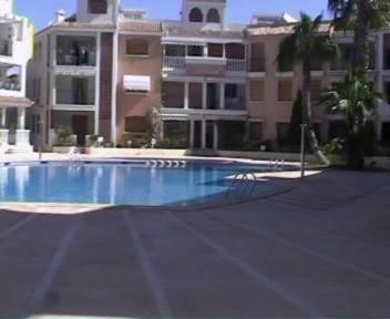 an empty swimming pool in front of a building at Apartamentos Pueblo Salado in Puerto de Mazarrón