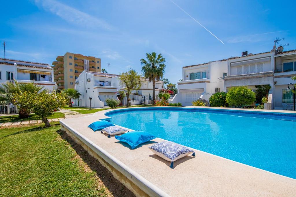 een zwembad met 2 ligstoelen naast een gebouw bij Ideal Property Mallorca - Avus in Alcudia