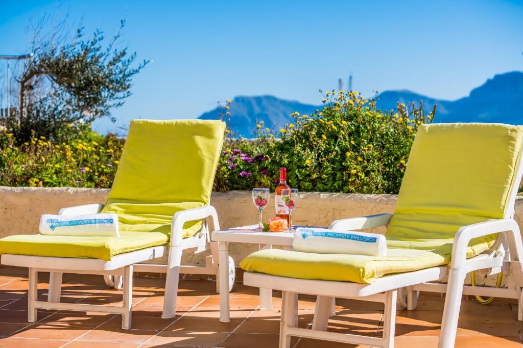 two lawn chairs and a table with a bottle of wine at Ideal Property Mallorca - Ca sa Tati in Son Serra de Marina