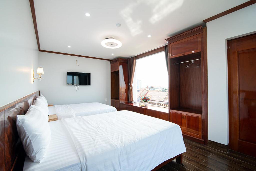 洞海的住宿－Minh Quang Hotel，一间卧室设有两张白色的床和窗户