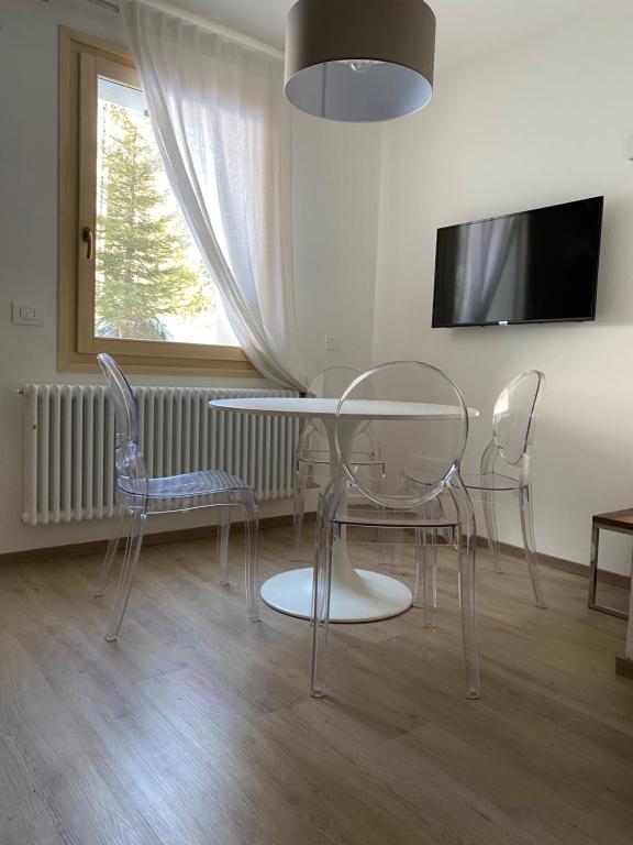 a dining room with a glass table and chairs at Baita Carlo Magno in Madonna di Campiglio