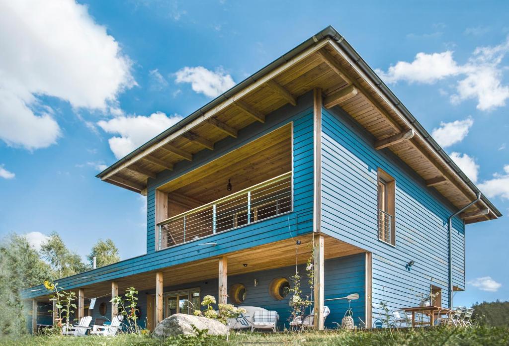 una casa con techo de gambrel en Family Lodge 50m from Lake with Sauna, en Brzozie