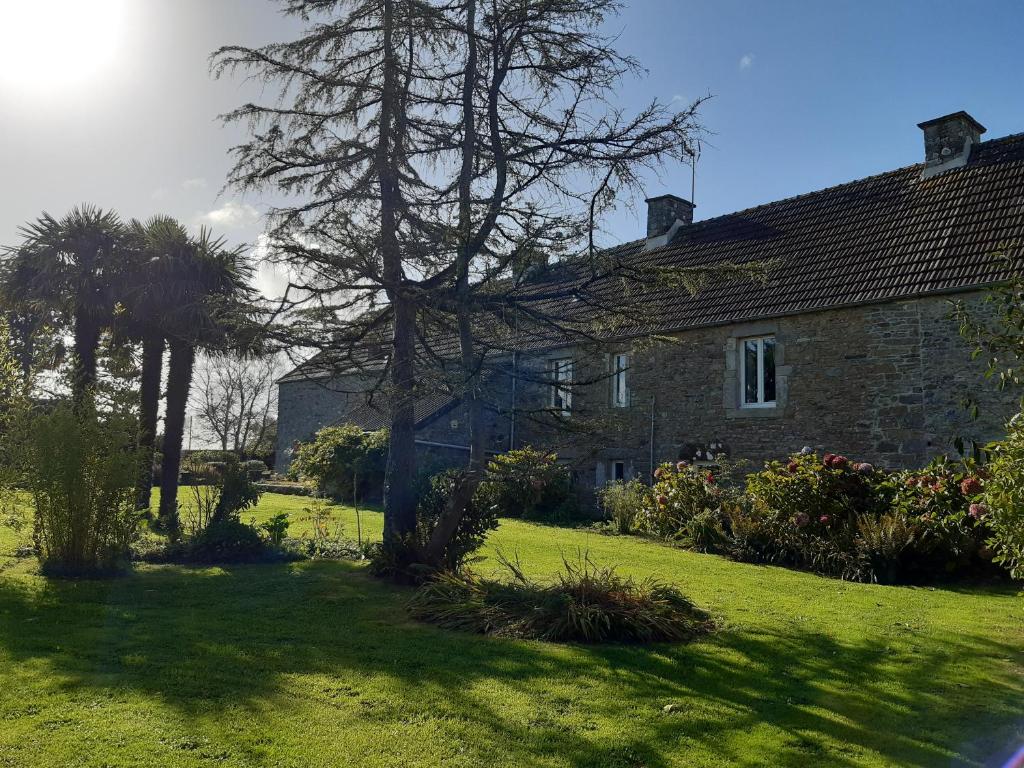 uma velha casa de pedra com uma árvore no quintal em A la Ferme de Saint Germain em Saint-Germain-le-Gaillard