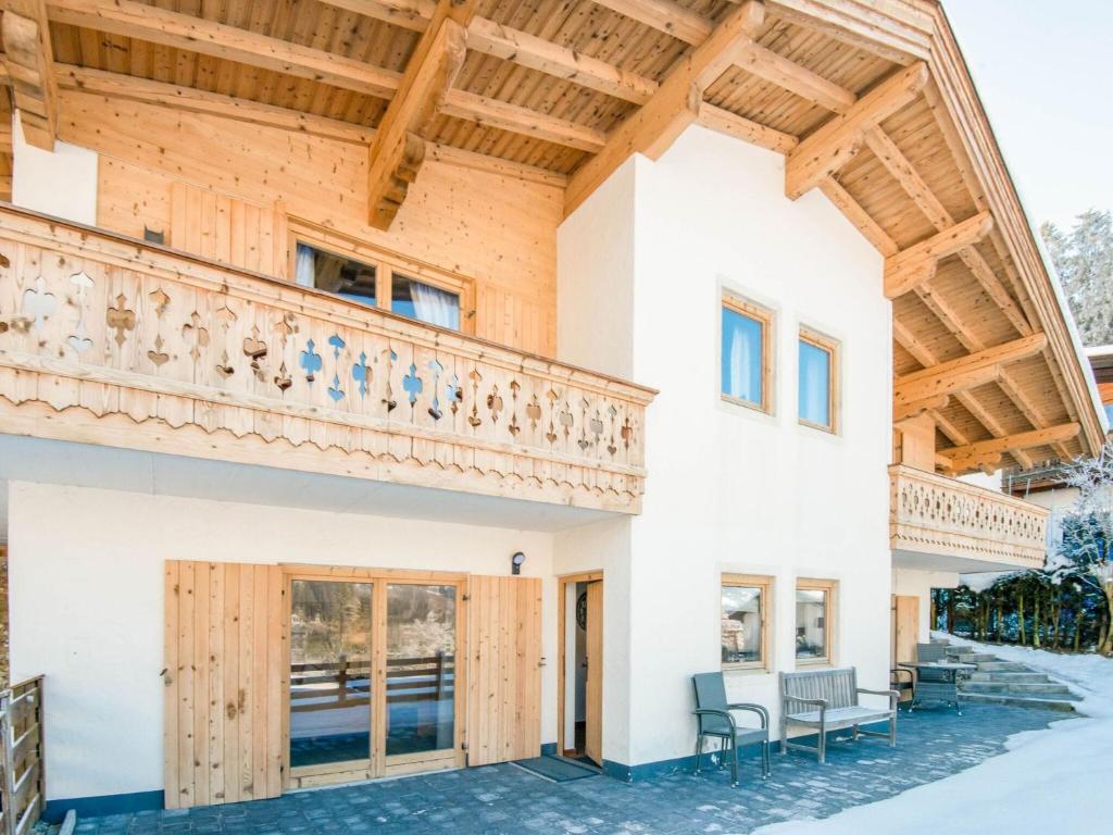 a house with a balcony and wooden ceilings at Valley View Apartment near Skiing Area in Kirchberg in Tirol