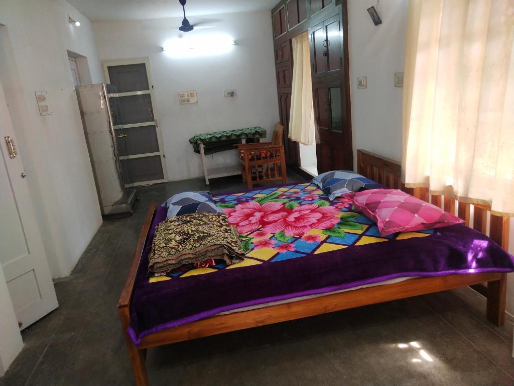 Mayurapriya Inn في تشيناي: غرفة نوم بها سرير عليه زهور