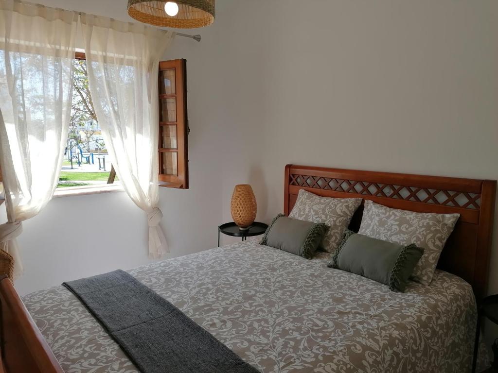 1 dormitorio con cama y ventana en Apartamento Riomar en Vila Nova de Milfontes