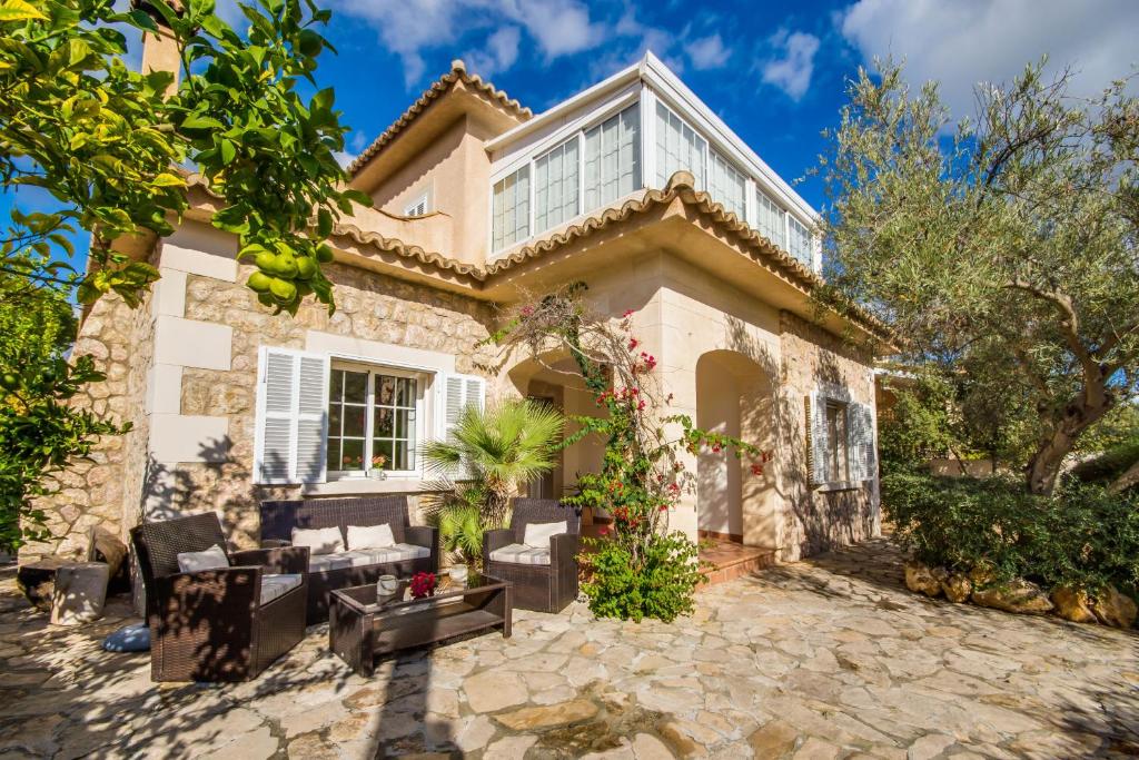 una casa con patio frente a ella en Ideal Property Mallorca - Can Olivo, en Puerto de Alcudia