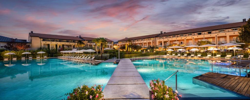 ein Hotel mit einem großen Pool vor einem Gebäude in der Unterkunft Hotel Caesius Thermae & Spa Resort in Bardolino