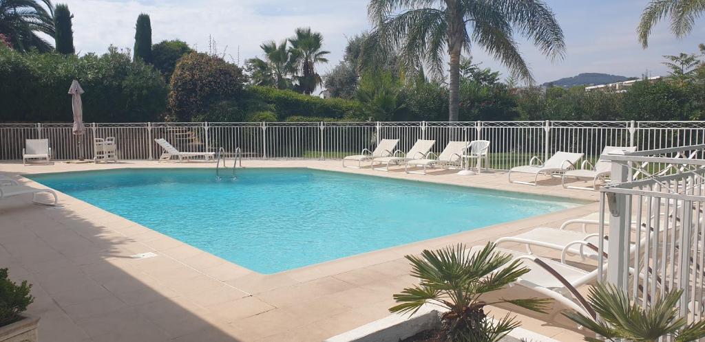 une grande piscine avec des chaises et une clôture dans l'établissement 3P PARC DE DIANE PISCINE, à Antibes