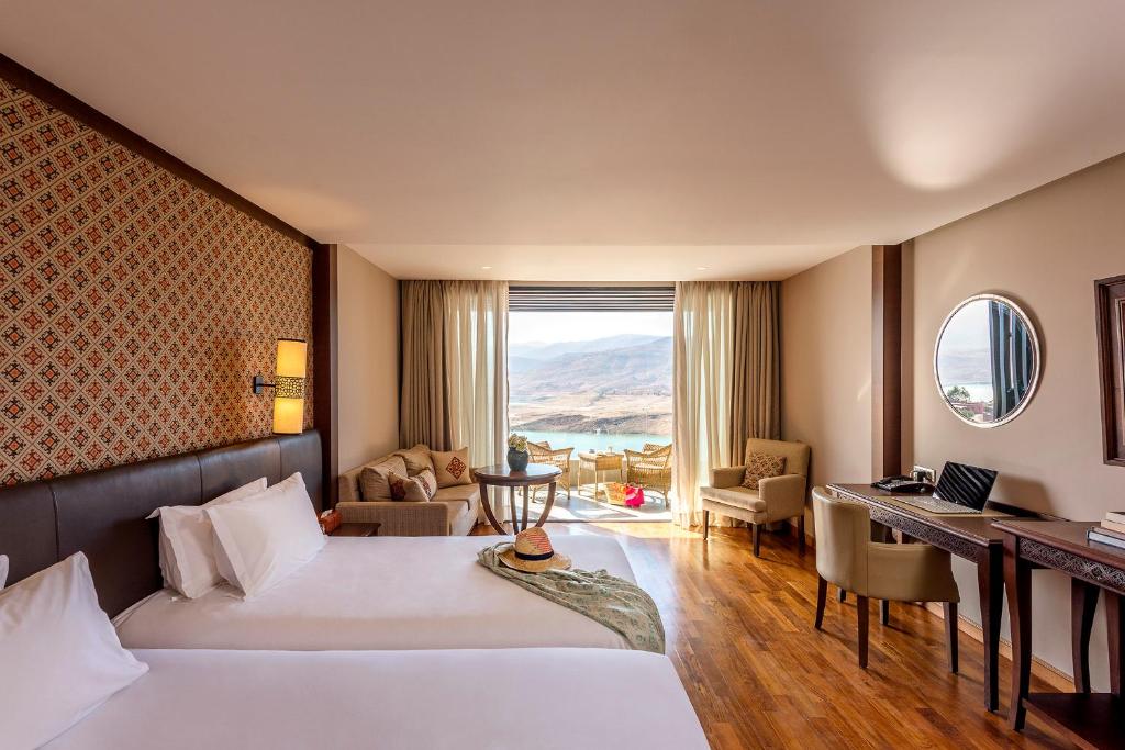 a hotel room with a large bed and a large window at Widiane in Bine el Ouidane