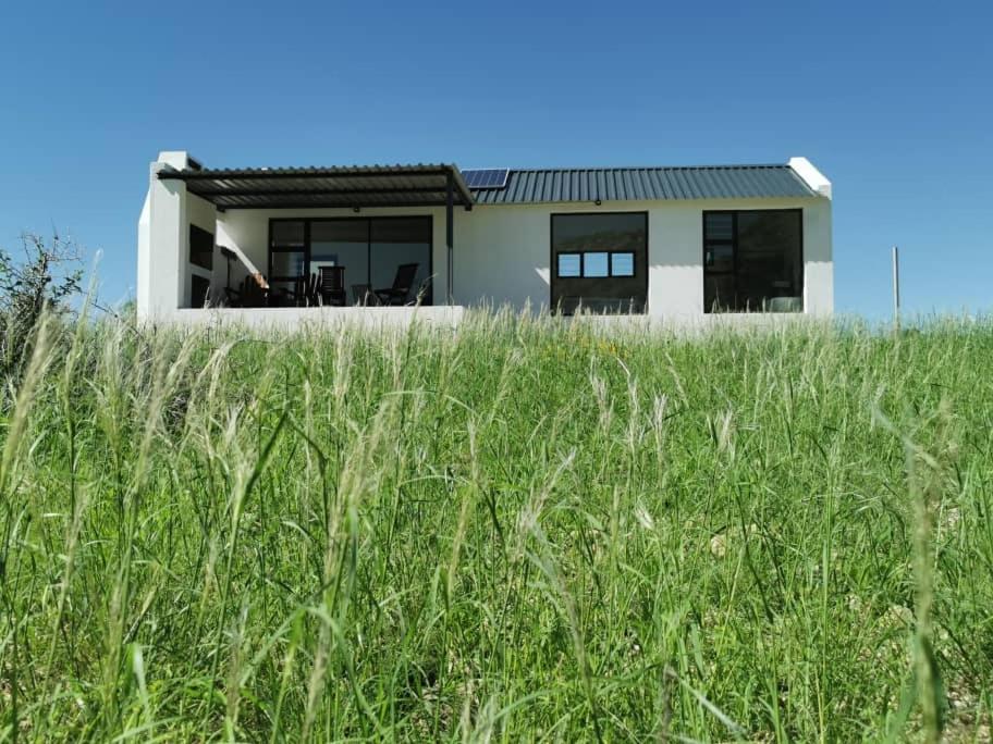 una casa en medio de un campo de hierba en Achab Eco cabin, en Usakos