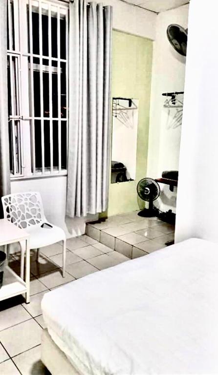 a bedroom with a white bed and a window at Ozzy Lodge Semporna in Semporna