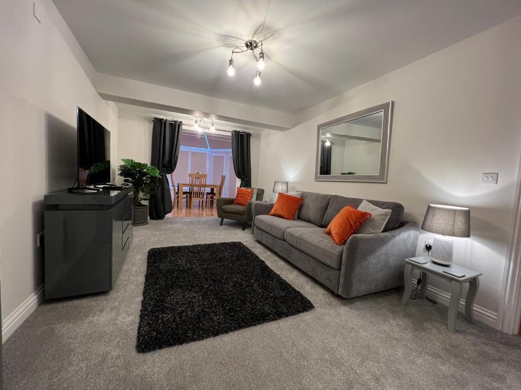 uma sala de estar com um sofá e uma mesa em Cotswold apartment with private parking! em Stow on the Wold