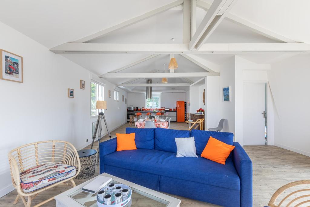 uma sala de estar com um sofá azul e almofadas laranja em Ti Kasino em Pléneuf-Val-André