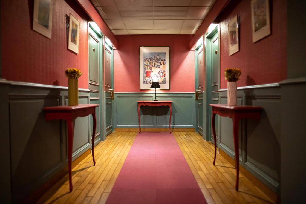 a hallway with green and red walls and two tables at Hotel De La Paix in Lille