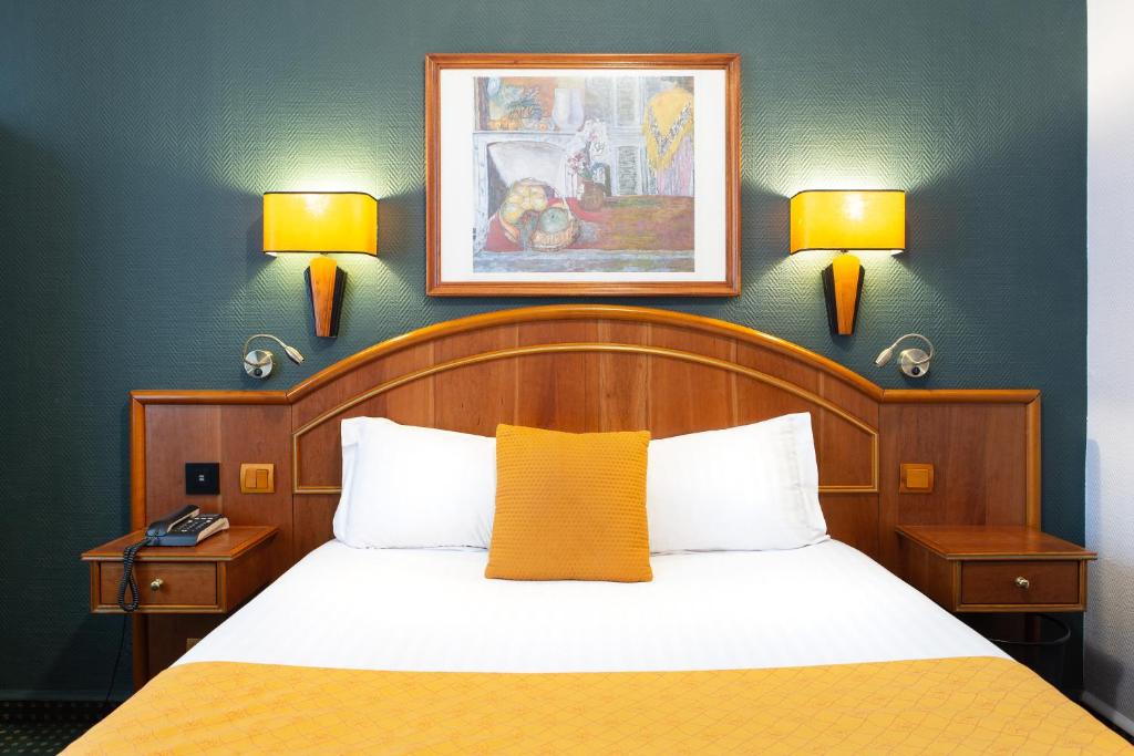 - une chambre avec un lit et deux lampes murales dans l'établissement Hotel De La Paix, à Lille