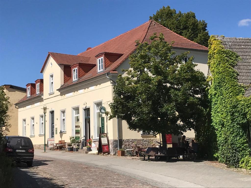 a white building with a tree in a street at Haus Seenland in Feldberg