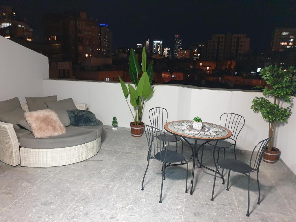 a patio with a couch and a table and chairs at LUXURY PENTHOUSE GREAT LOCATION WITH PARKING Tlv in Ramat Gan