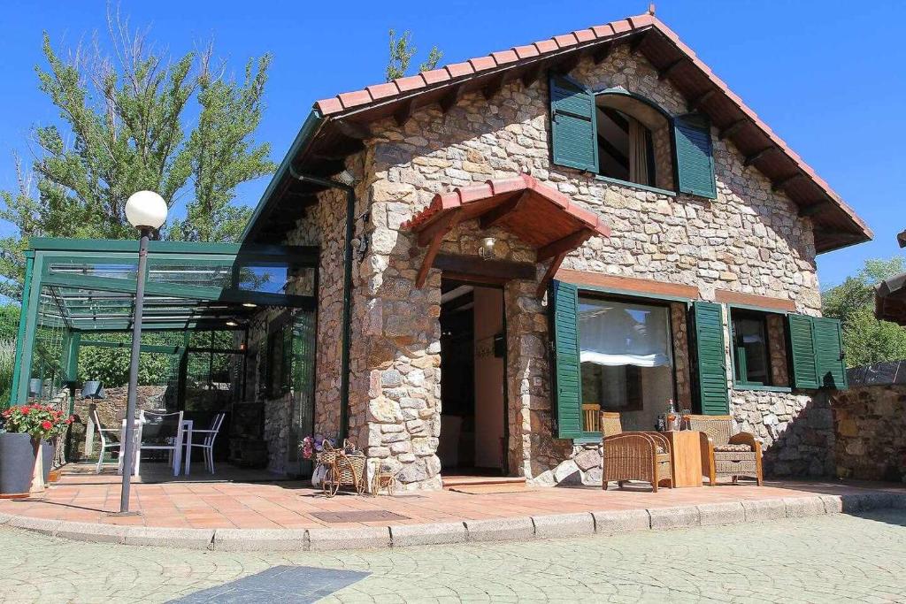 a small stone house with a porch and a patio at Casa rural la castañona in Buiza