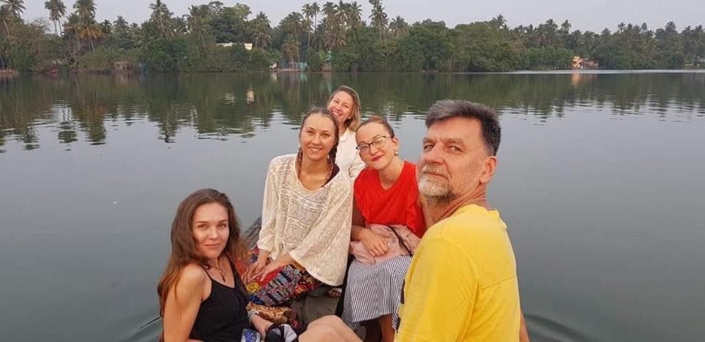 a group of people sitting on a boat on a lake at Ambadi's villa -Lake view resort in Pallipuram