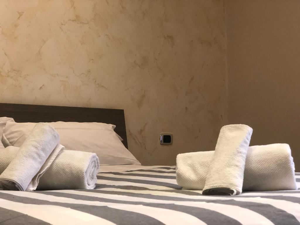 a bed with white pillows on top of it at Portuense Sweet Home in Rome