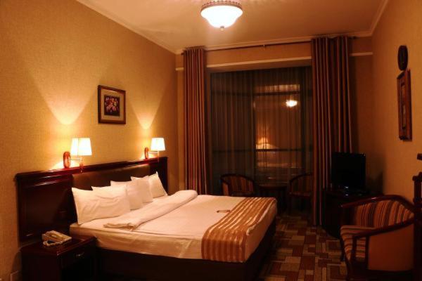 a hotel room with a bed and a window at Asia Grand Hotel in Dushanbe