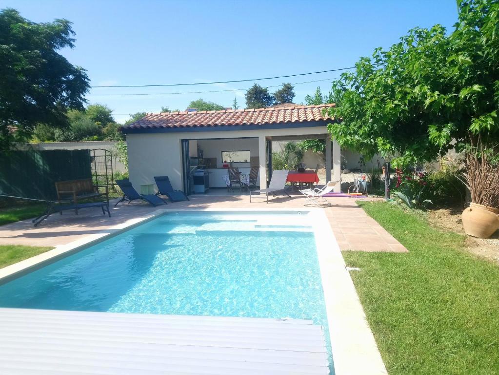 une piscine dans la cour d'une maison dans l'établissement La Maison des Romarins Chambres Cosy Climatisées Piscine Cuisine, à Aigremont