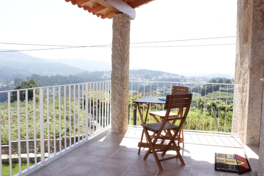 a patio with a table and a chair on a balcony at Casa da Nininha in Vale de Cambra