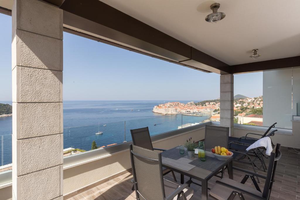 einen Balkon mit einem Tisch und Stühlen sowie Meerblick in der Unterkunft Amorino Of Dubrovnik Apartments in Dubrovnik