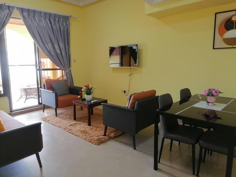 sala de estar con mesa y sillas en Cheerful 2-bedroom Apartment with free parking, en Kumasi