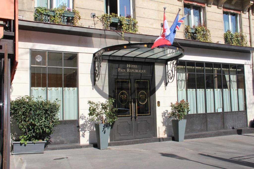un edificio con una porta con una bandiera di Hotel Paix Republique a Parigi