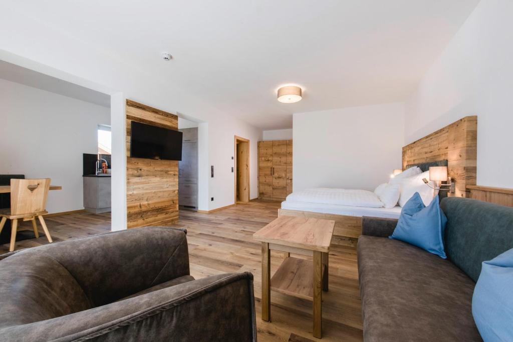 - une chambre avec un lit, un canapé et une table dans l'établissement Kopeindlgut Apartments, à Wals