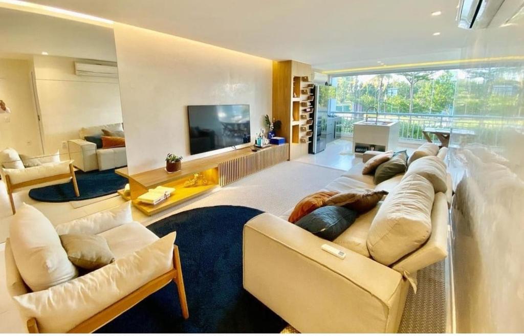 uma grande sala de estar com um sofá e uma televisão em Golf Ville Resort in Beach Park em Aquiraz