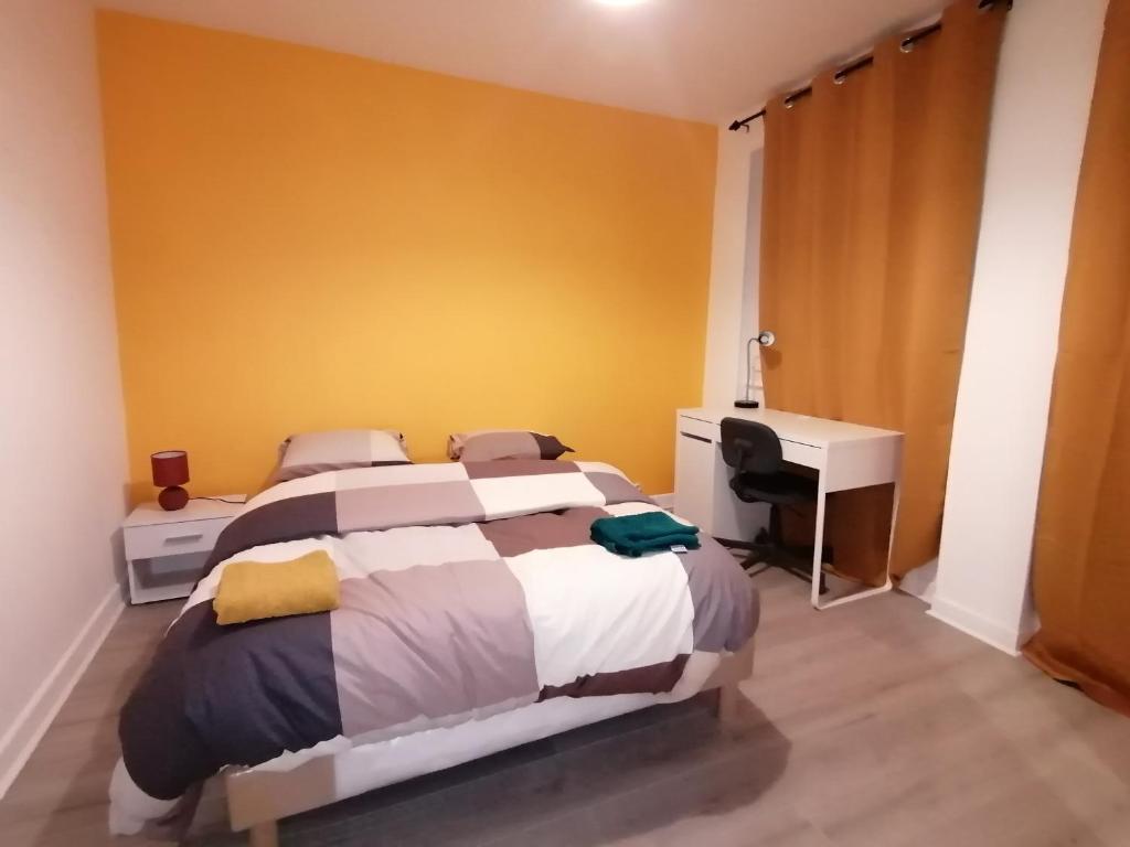 a bedroom with a bed and a desk and a computer at Hadriel Host in Clermont-Ferrand
